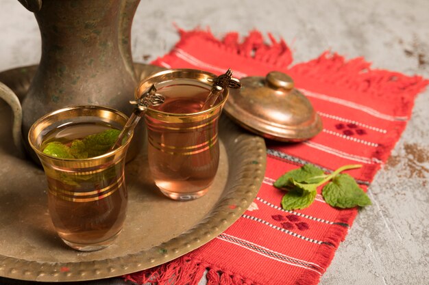 Té árabe en vasos con menta en bandeja