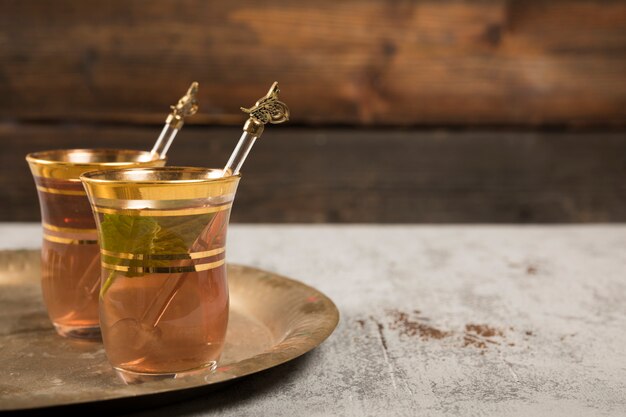 Té árabe en vasos con menta verde en bandeja