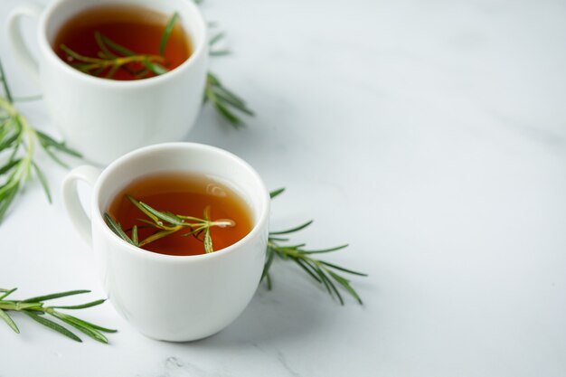 Té caliente de romero en taza listo para beber