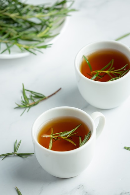 Té caliente de romero en taza listo para beber