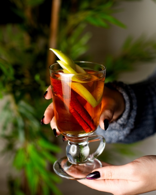 Té de frutas calientes con manzana y canela en un vaso