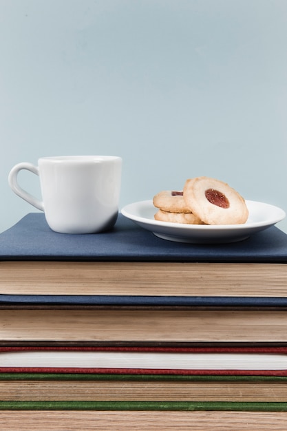 Té y galletas en la pila de libros