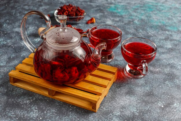 Té de hibisco caliente en una taza de vidrio y una tetera de vidrio.