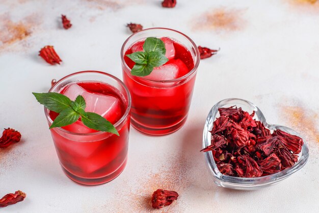 Té de hibisco frío con hielo y hojas de albahaca.