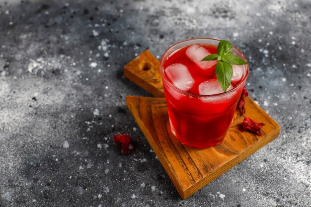 Té de hibisco frío con hielo y hojas de albahaca.