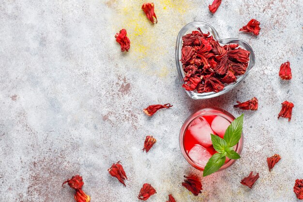 Té de hibisco frío con hielo y hojas de albahaca.