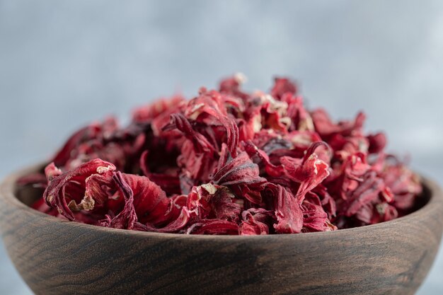 Té de hibisco seco en un tazón de madera.