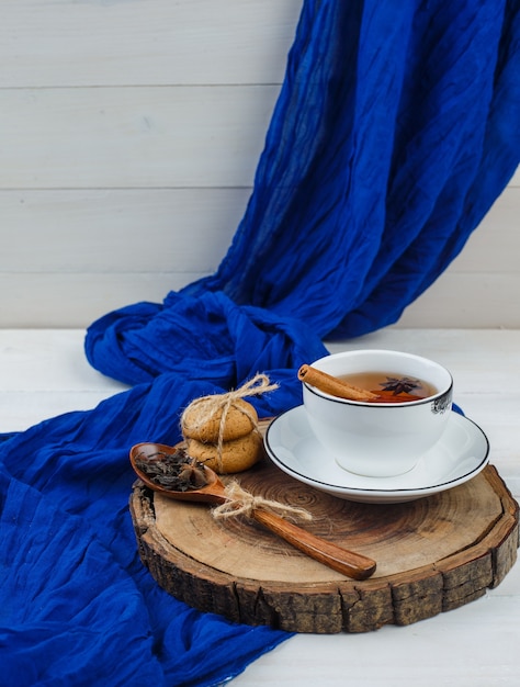 Té de hierbas, galletas y panqueques sobre tabla de madera