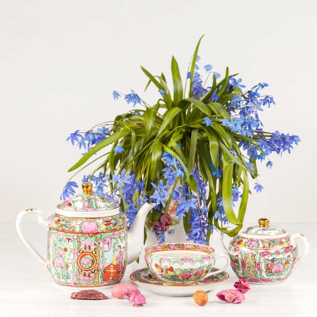 Té con limón y bouquet de prímulas azules sobre la mesa