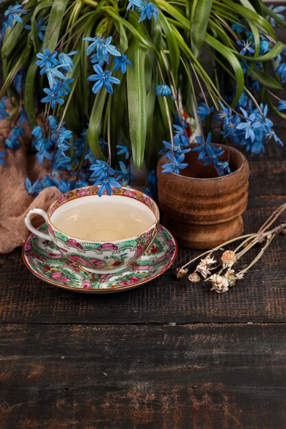 Té con limón y bouquet de prímulas azules sobre la mesa