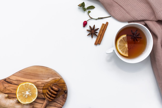 Té con limón cerca de tabla con cazo de miel