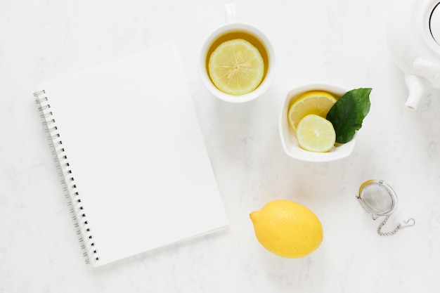 Té de limón con cuaderno en blanco