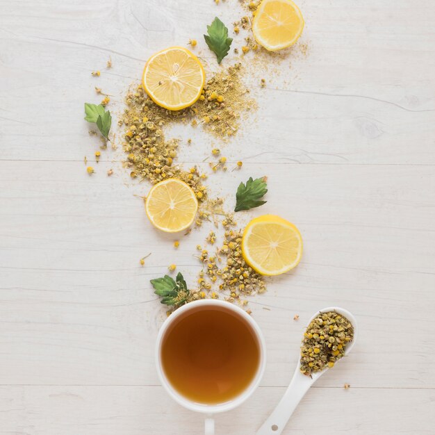 Té de limón con flores de crisantemo chino seco y rodajas de limón en mesa de madera