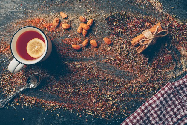 Té de limón y hierbas secas con canela seca, cuchara y almendras planas