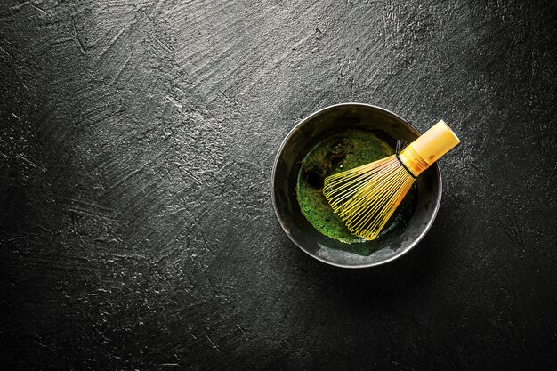 Té Matcha en un tazón negro en la oscuridad