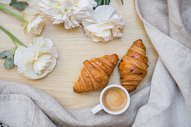 Té con medialunas cerca de hermosas flores