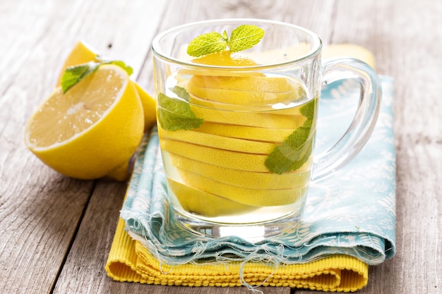 Té con menta y limón entero en una taza transparente