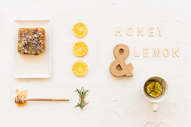 Té de miel y limón con panal, rodajas de limón y romero