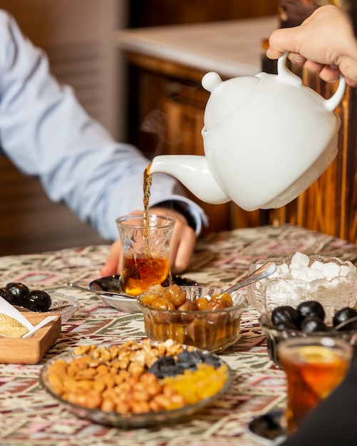 Foto gratuita té negro en vidrio armudu sobre la mesa