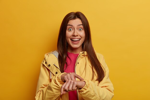 Te estas quedando sin tiempo. La estudiante positiva señala en la muñeca, en el reloj invisible, es muy puntual y llega a tiempo.