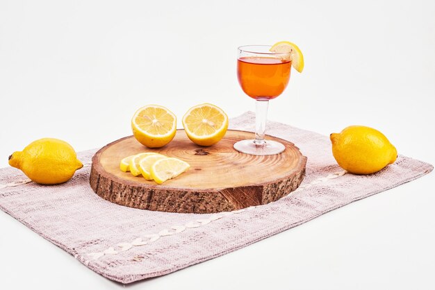 Té verde con limones sobre superficie blanca.