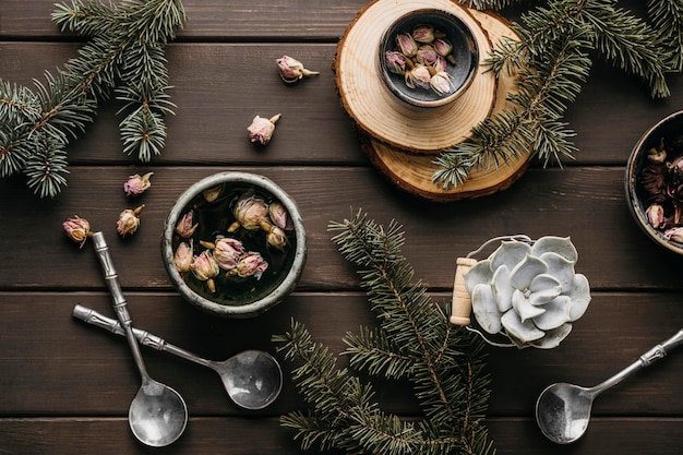 Té de vista superior con flores secas y ramas de pino