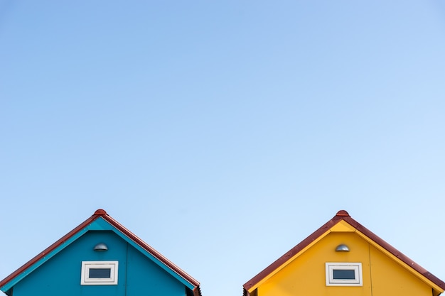 Techos de pequeñas casas azules y amarillas con copyspace en el cielo