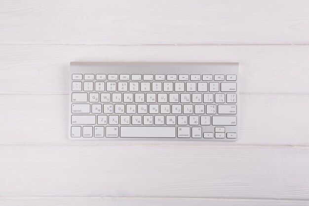 Teclado blanco sobre mesa de madera