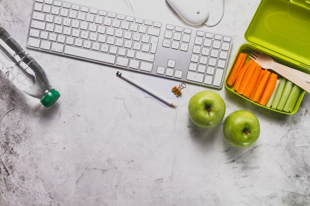 Teclado con botella de agua y comida saludable