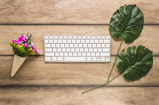 Teclado de computadora con hojas y flores