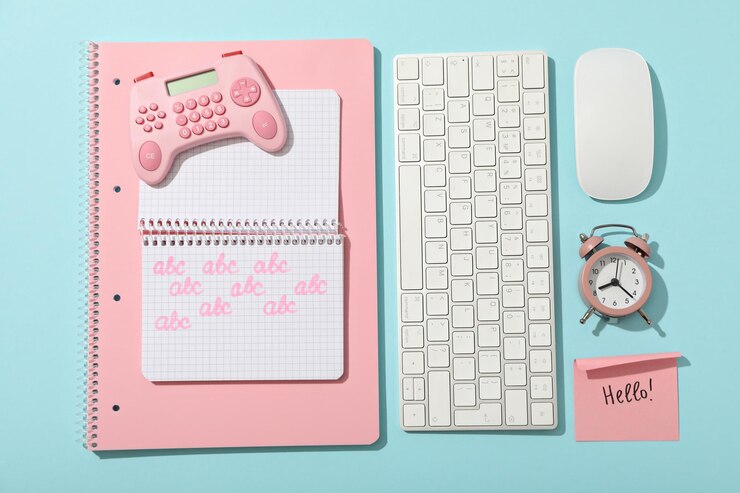 Foto gratuito un teclado de computadora con un ratón y un cuaderno en un fondo azul