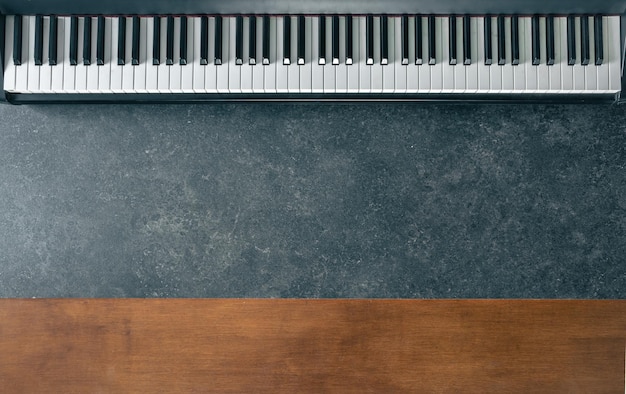 teclado de piano en un mármol oscuro y superficie de madera vista superior