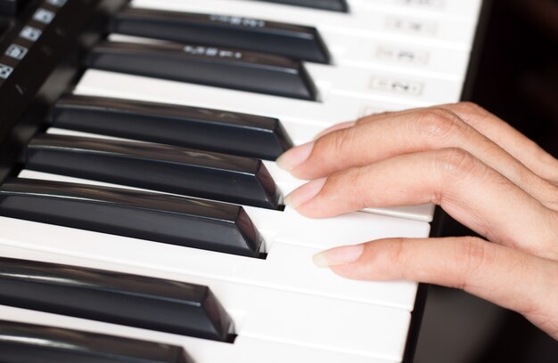 Teclado de piano con una mujer