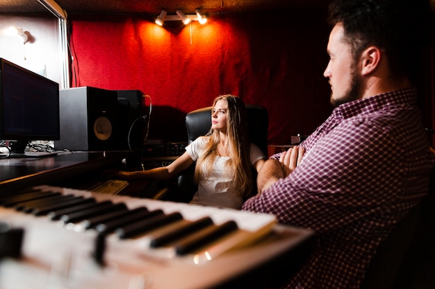 Foto gratuita teclado de primer plano y personas que dominan las canciones