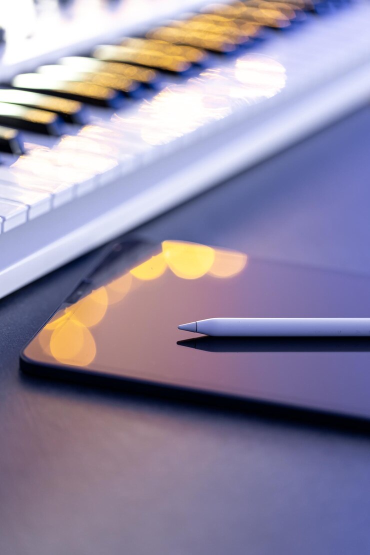 Foto gratuito las teclas musicales y una tableta con un lápiz en la mesa