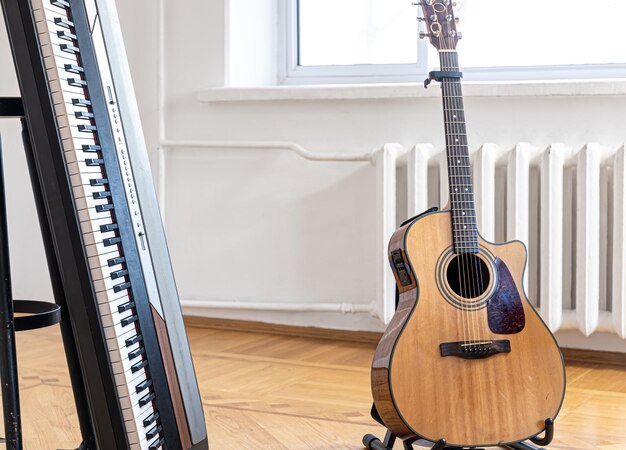 Teclas de piano y guitarra acústica en el interior de una habitación luminosa