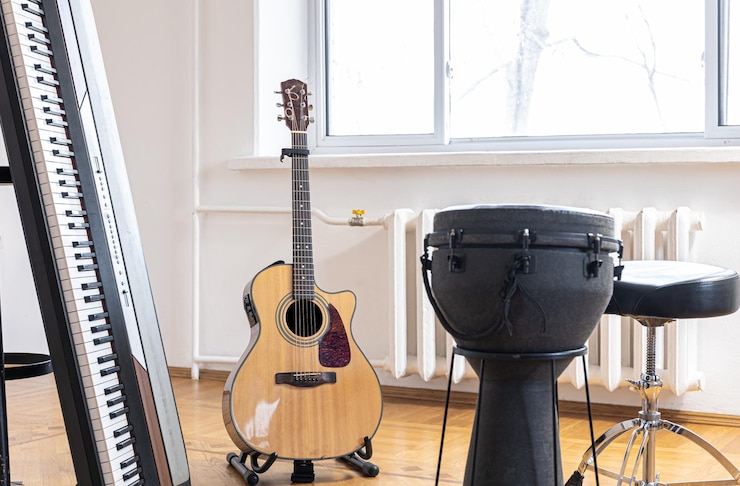 Foto gratuito las teclas del piano y la guitarra acústica en el interior de una habitación luminosa