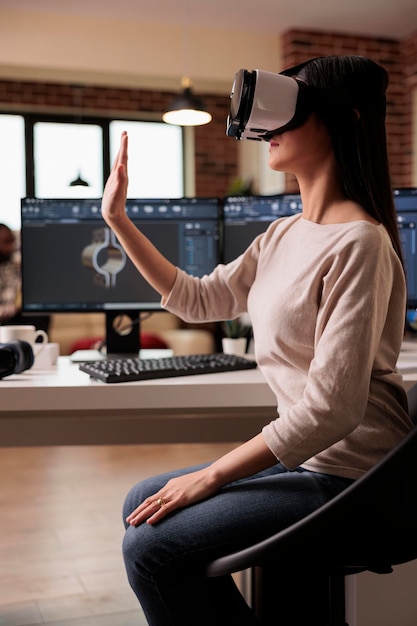 Foto gratuita técnico asiático con gafas vr desarrollando productos, ayudando con la producción de maquinaria industrial. modelo de engranajes de fabricación de ingenieros de cad con software y auriculares 3d de realidad virtual.