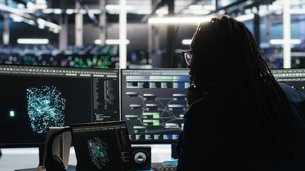 Técnico del centro de servidores que llega a la oficina usando información de visualización de IA en la PC