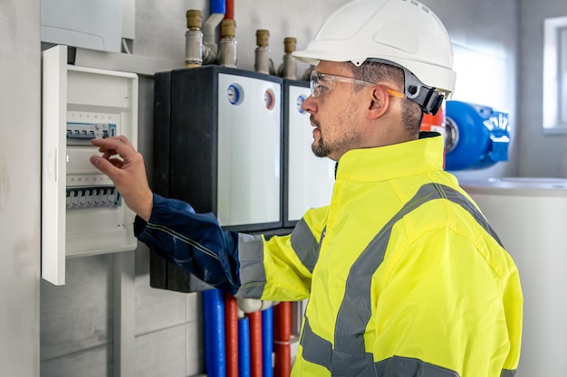 Técnico eléctrico que parece concentrado mientras trabaja en un cuadro de distribución con fusibles