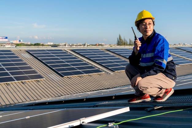 Técnico especialista ingeniero profesional con control de mantenimiento de computadoras portátiles y tabletas instalando un panel de techo solar en la azotea de la fábrica bajo la luz del sol