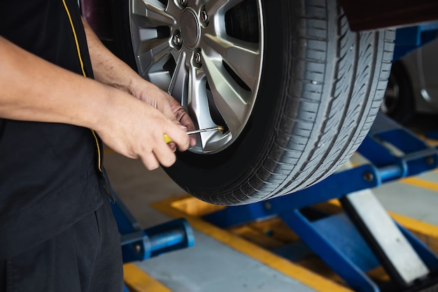 El técnico está inflando el neumático del automóvil, servicio de mantenimiento del automóvil, seguridad de transporte