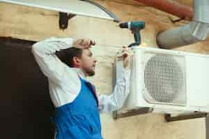 Foto gratuita técnico de hvac trabajando en una parte del condensador para la unidad de condensación