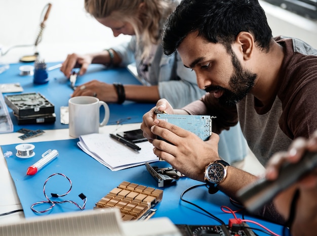 Técnicos eléctricos trabajando en piezas electrónicas.