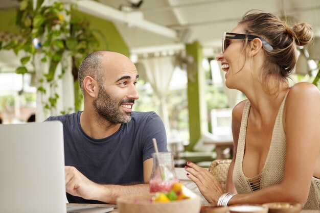 Tecnología y comunicación. Dos amigos conversando animadamente durante el almuerzo.