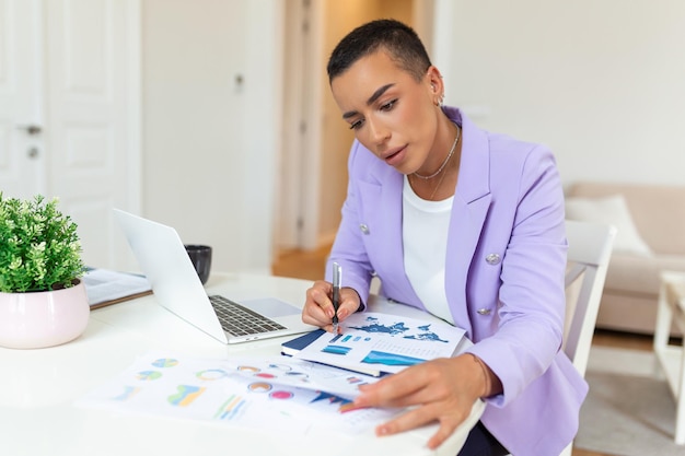 Tecnología de trabajo remoto y concepto de personas joven mujer de negocios africana con computadora portátil y papeles que trabajan en la oficina en casa durante la crisis de salud de Covid19