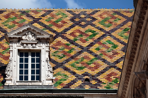 Tejas de tejado de cerámica tradicionales en un edificio del gobierno en Dijon, Borgoña, Francia.