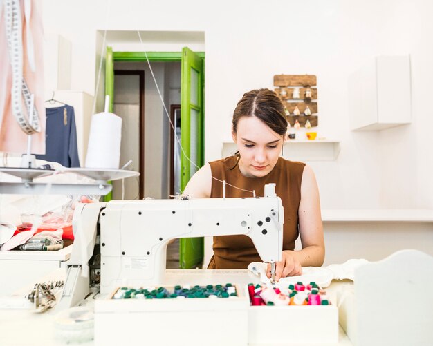 Tela de costura hermosa mujer diseñador en la máquina de coser