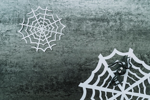 Foto gratuita tela de papel con araña de juguete sobre fondo gris
