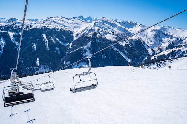 Teleférico del remonte sobre las hermosas montañas cubiertas de nieve